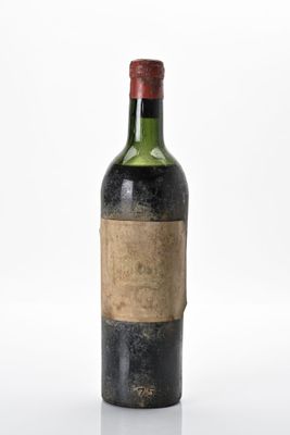 une vieille bouteille de vin posée sur une surface blanche