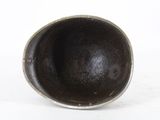 a small black bowl sitting on a white surface