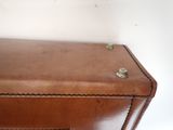 a brown piece of luggage sitting on top of a table