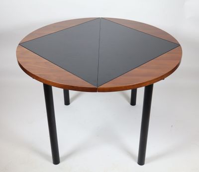 a round table with a black top and wooden legs
