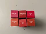 four different shades of lipstick are arranged on a white surface