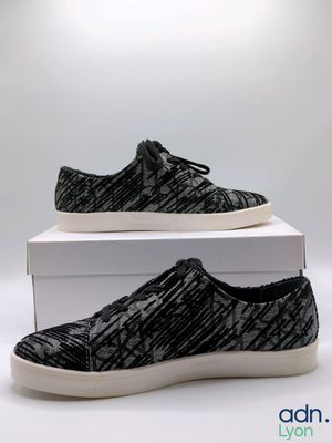 a pair of black and white sneakers sitting on top of a box