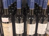 several bottles of wine are lined up on a shelf in a store