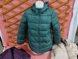 un manteau, un sac et un sac à main posés sur un lit