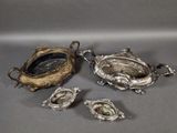 four pieces of silverware including a bowl, spoon, and spoon rest