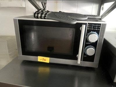 a microwave sitting on top of a counter with a keyboard