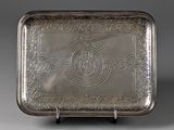 an antique silver tray with a design on the front