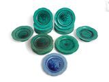 plusieurs morceaux de verre bleu et vert posés sur une surface blanche