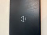 a dell laptop sitting on the wall next to a remote control
