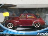 une petite voiture rouge dans une boîte posée sur une table