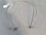 silver plated headband with two beads and a tag on it