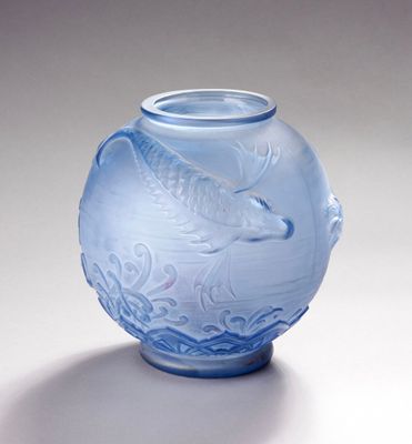 un vase bleu orné d'un poisson, posé sur une table