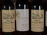 three bottles of red wine are lined up on a table
