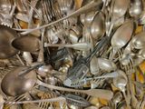 de nombreuses cuillères en argent et de nombreuses cuillères à soupe sur la table