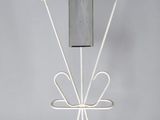 une sculpture métallique représentant un téléphone portable posé sur un socle