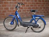 an image of a blue bike parked in front of a brick wall