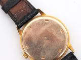 a close up of a watch on a white surface
