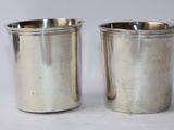 two silver cups sitting next to each other on a table