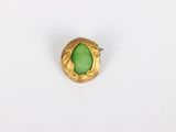 a close up of a ring with a green stone in it