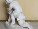 a statue of a boy kneeling on a surfboard