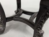 a close up of the legs of a table with a clock on it