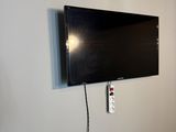 une télévision à écran plat fixée au mur dans un coin de la pièce