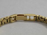 a close up of a gold bracelet on a white surface