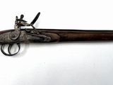 un vieux pistolet avec un canon en bois et une poignée en métal