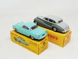 two toy cars sitting on top of a box on a white surface