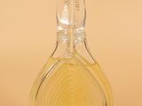 an image of a bottle of perfume sitting on top of a table