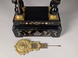 a black and gold desk with a clock next to it