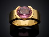 a gold ring with a pink tourmaline stone in the center