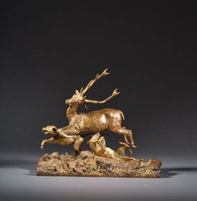 une sculpture en bronze représentant un cerf et une biche sur un rocher