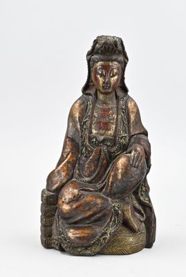 l'image d'une statue de femme assise sur un rocher