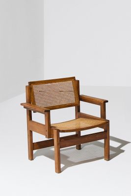La chaise est en bois et son assise est en rotin.