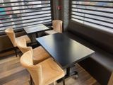 a black table with four chairs and a black table in front of a window