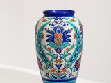 un vase bleu et blanc posé sur une étagère blanche