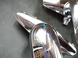 two chrome spoons sitting on a table with a box in the background