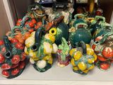 a pile of ceramic figurines sitting on a white shelf