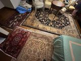 a room with a lot of rugs and chairs in it