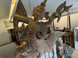 a statue of a woman riding a dragon on a table