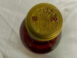 a bottle of honey with a gold lid on a table