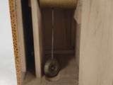 a wooden clock that is sitting in the corner of a cabinet