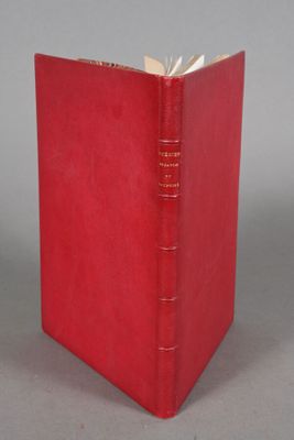 a red book sitting on top of a table next to a gray wall
