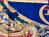 a close up of a colorful scarf with a bird on it