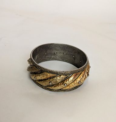 an image of a gold and silver ring on a white surface