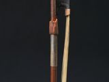 a close up of a metal and wood pole with a black background