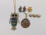 several pieces of jewelry including an owl, a necklace, and a key