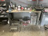 une photo d'un établi dans un garage, avec de nombreux outils