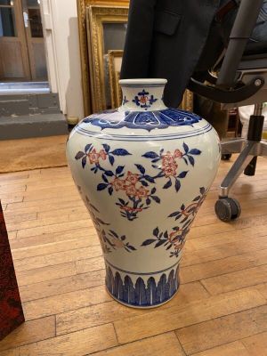 un vase posé par terre devant une chaise
